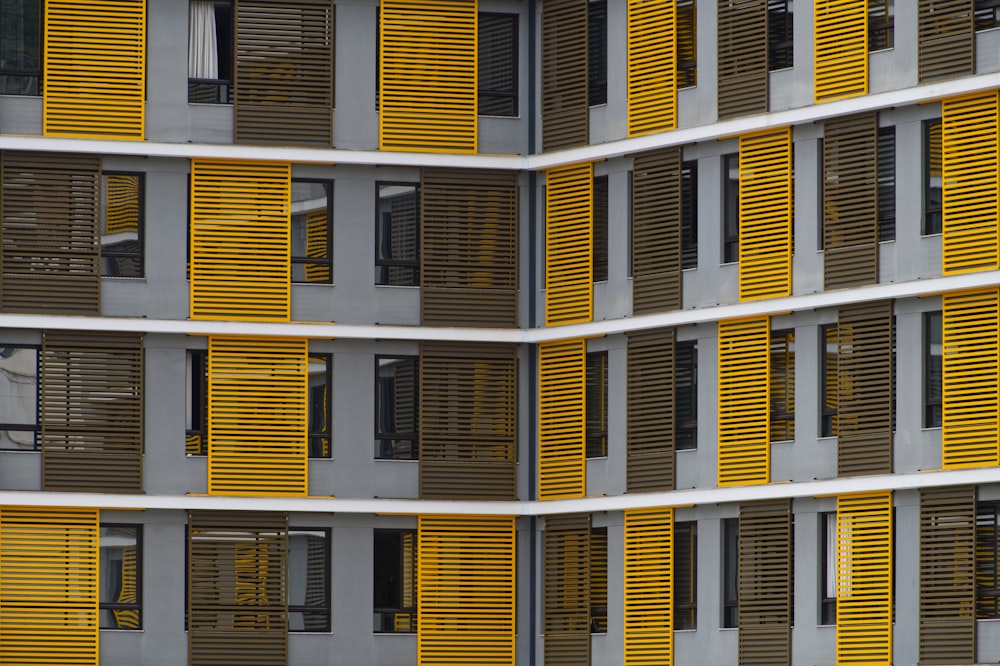 a tall building with yellow shutters on the windows