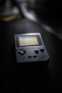 Close-up of a vintage handheld gaming console with visible buttons and screen.
