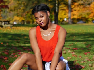 a woman sitting on the ground in a park