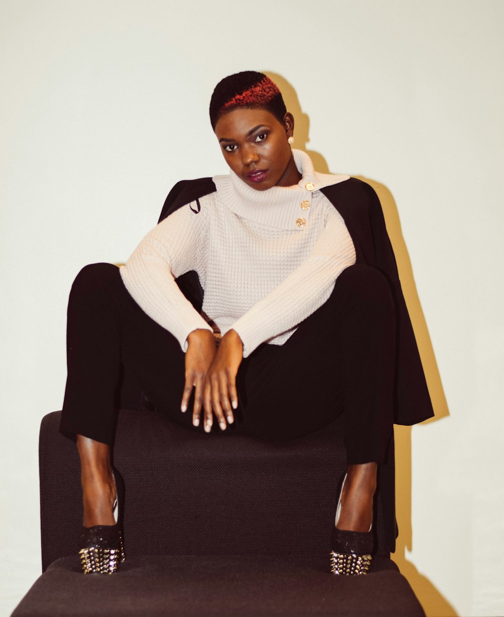 a woman sitting on top of a black chair