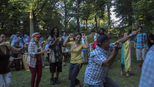 A group of diverse volunteers planting trees together in a vibrant community park.
