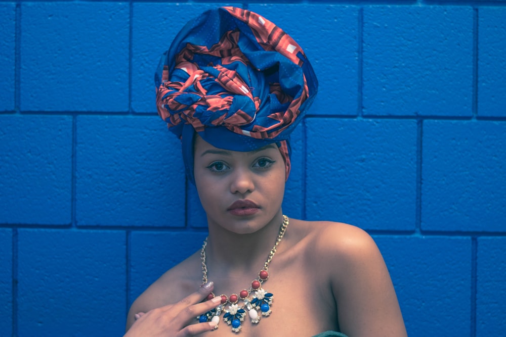 a woman wearing a blue hat and necklace