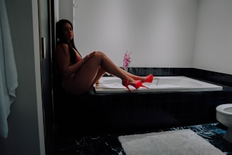 a woman sitting on a bathtub in a bathroom