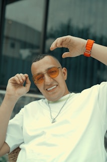 A customer wearing a wristband and pendant from the collection, smiling outdoors.