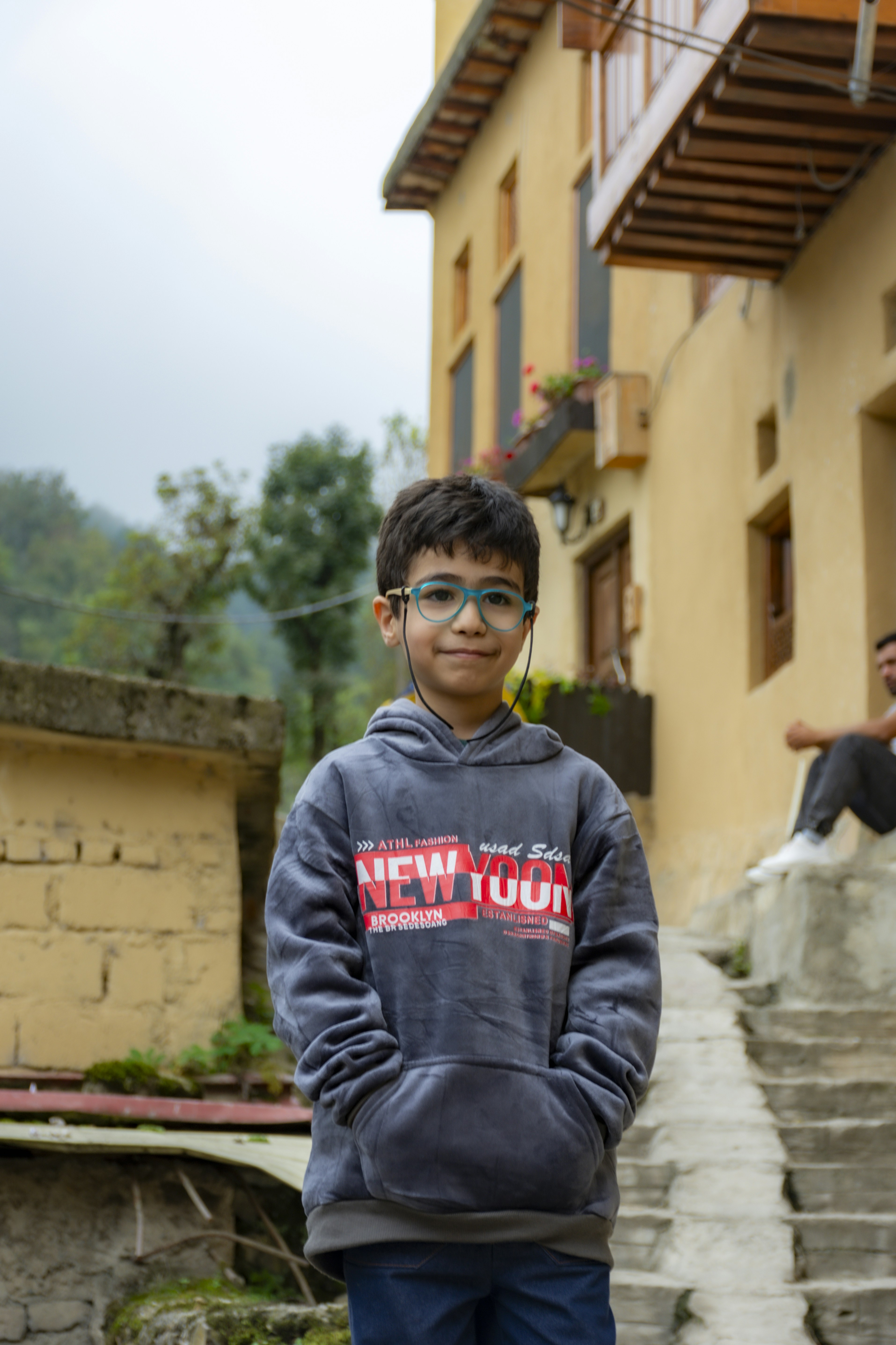 A young boy standing in front of a building