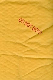 a piece of yellow paper with a red do not bed sticker on it