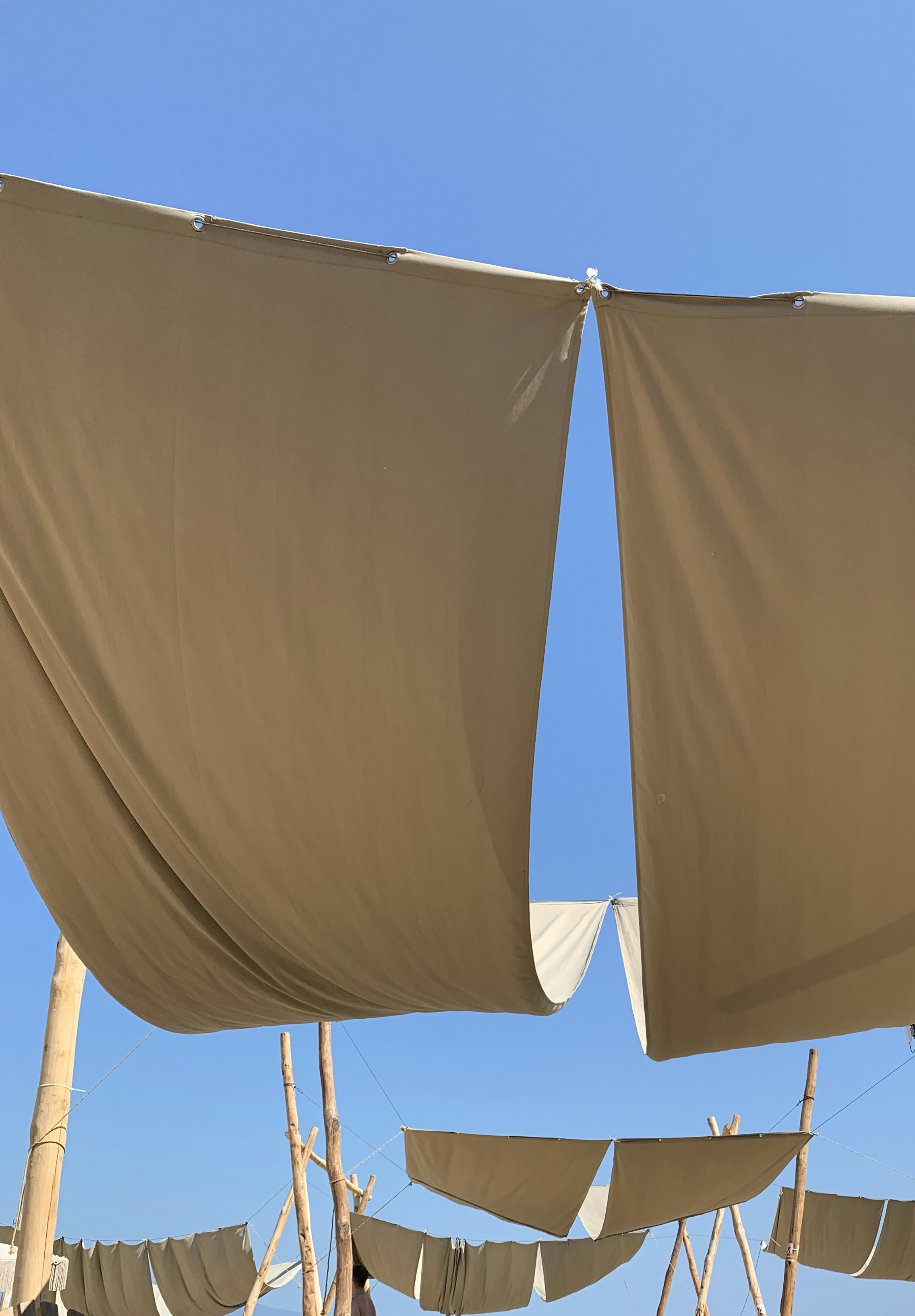 a group of tan cloths hanging from a line