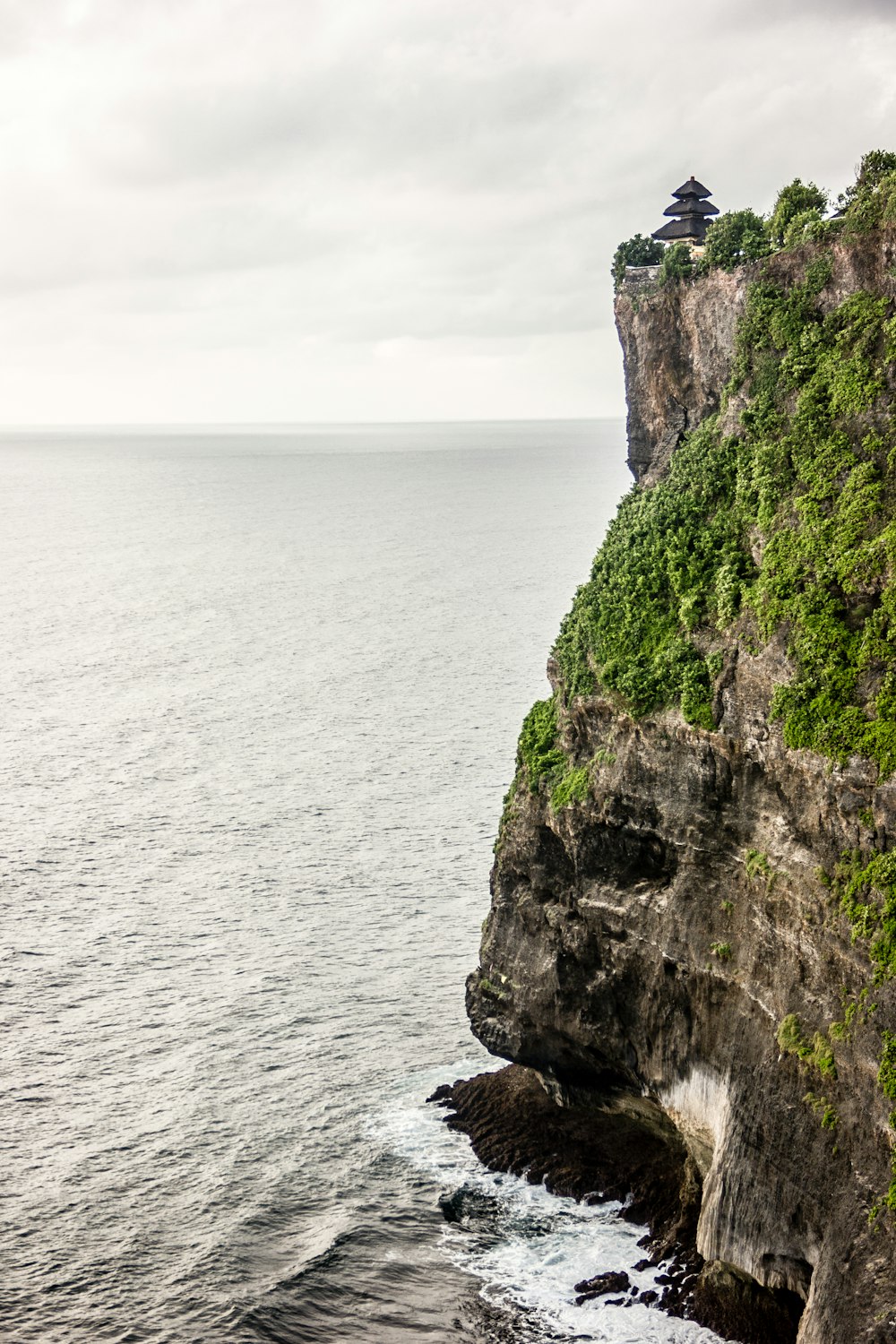 a large cliff with a small tower on top of it