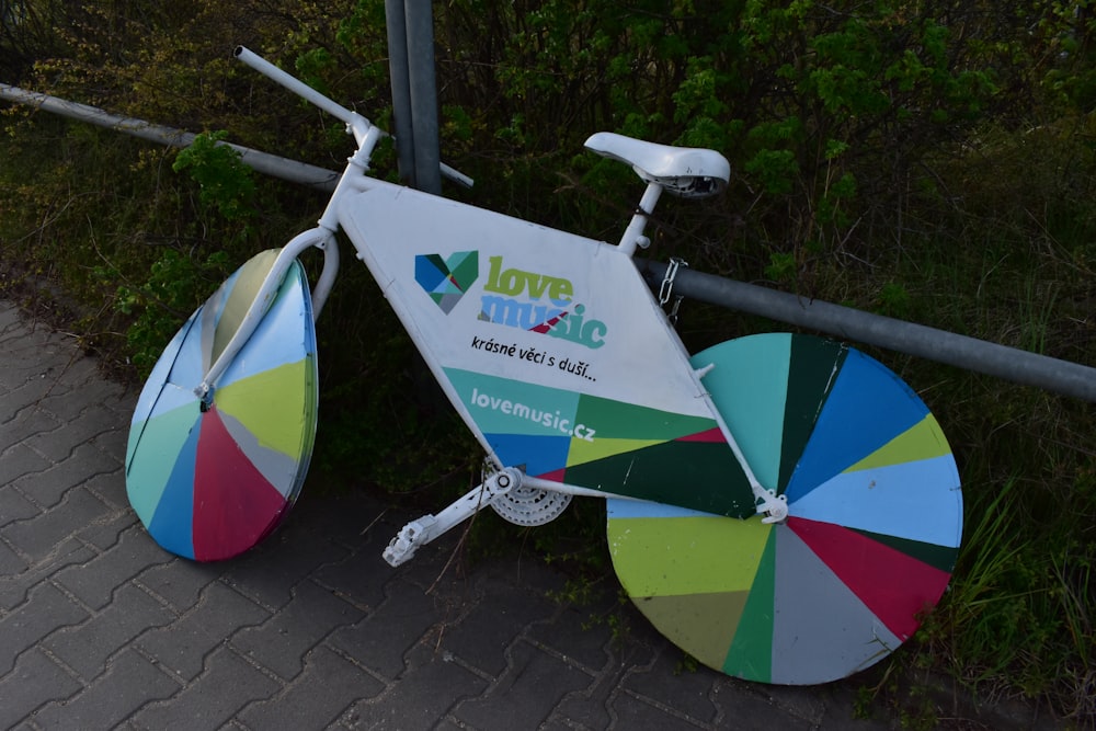 a colorful bicycle parked next to a metal fence