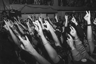 a crowd of people raising their hands in the air