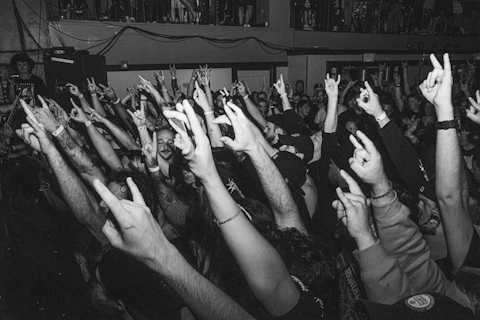 a crowd of people raising their hands in the air