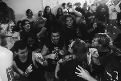 An energetic host engaging a crowd with microphone, surrounded by smiling participants.