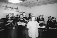 A participant practicing a speech with supportive peers applauding.