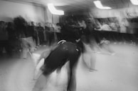 A candid event photo with dynamic movement, high contrast black and white tones, and a splash of burnt orange.