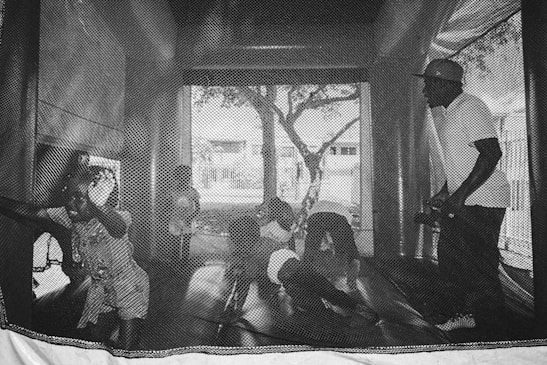 A colorful digital image of a bounce house filled with happy children.