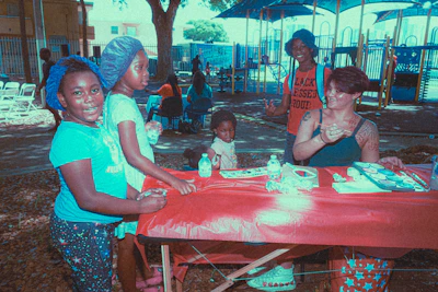 A warm family gathered around a table, collaborating on a vibrant craft project outdoors.