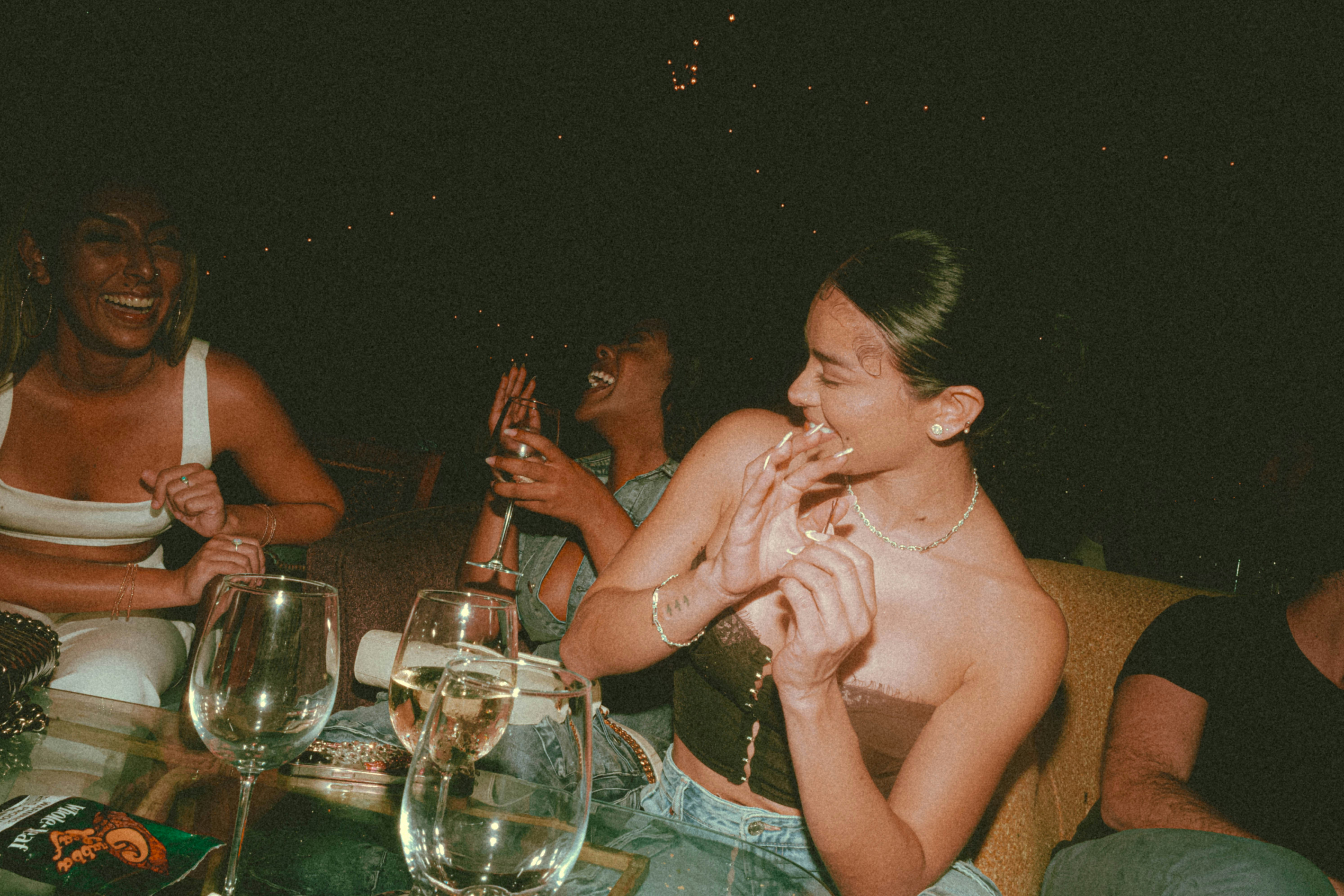 a group of people sitting around a table with wine glasses