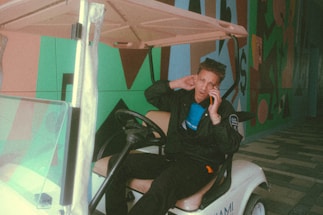 A friendly customer service representative answering a call with golf carts in the background.