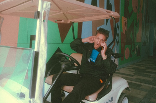 A friendly customer service representative answering a call with golf carts in the background.