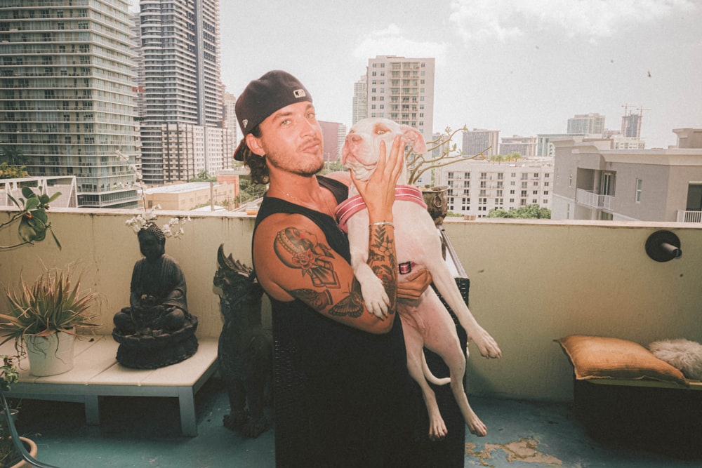 a man holding a dog on top of a roof