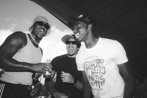 Men sharing stories and laughter around a wooden table.