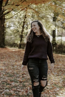 Casual chic ensemble on a model walking through a sunlit park with autumn leaves.