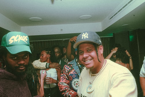 Group of friends wearing personalized caps at a lively outdoor party.