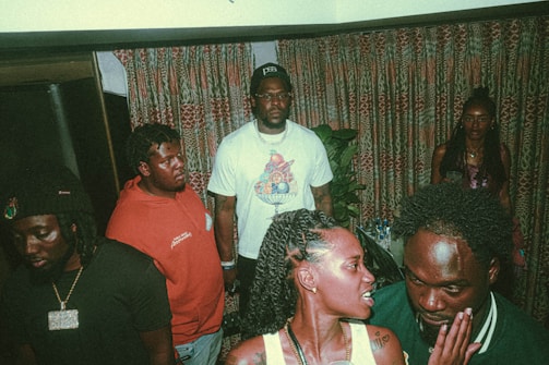 A group of diverse people sharing stories around a microphone in a cozy setting.