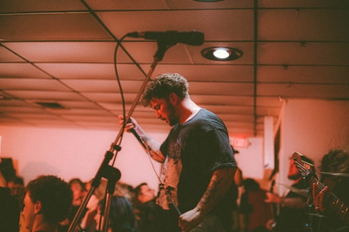 Kazi Manam Ahemed performing on a small stage, intimate audience listening closely.