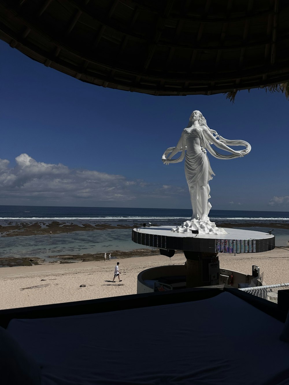 a statue of a woman on a beach near the ocean