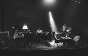 Agents and players sharing a focused conversation in a dimly lit room with crimsonscout logos subtly displayed