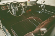 Interior shot showcasing supple leather seats and vintage dashboard details under soft ambient lighting.