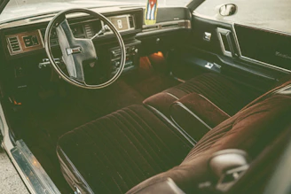 Interior shot showcasing supple leather seats and vintage dashboard details under soft ambient lighting.