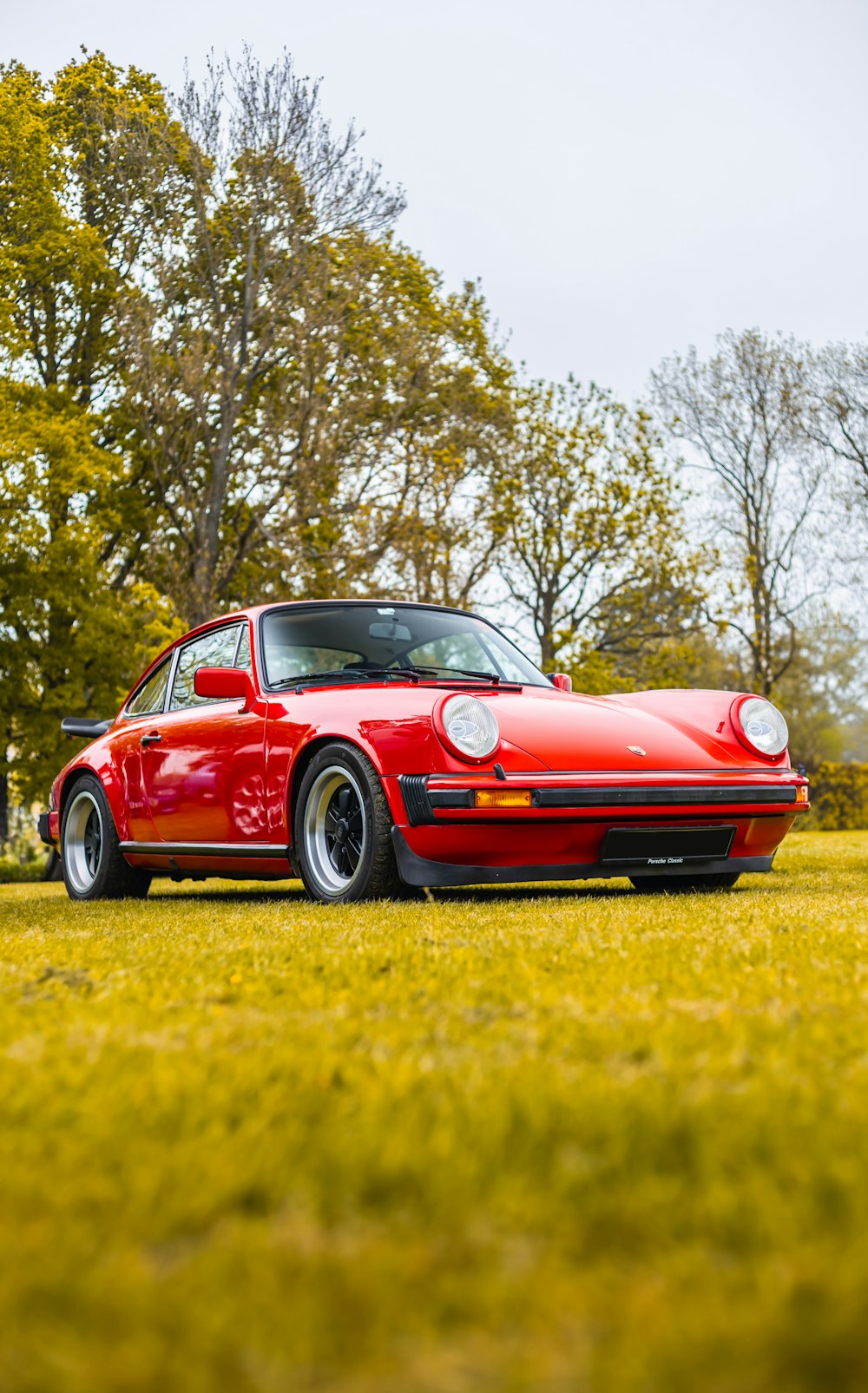 a red sports car parked in a grassy field