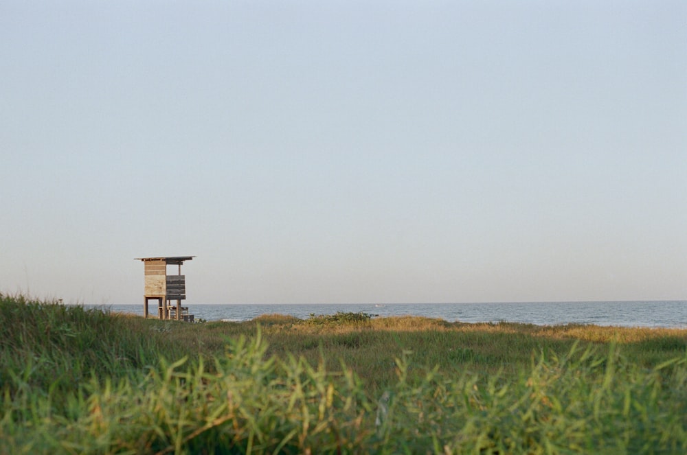 a lifeguard stand on a grassy hill overlooking the ocean