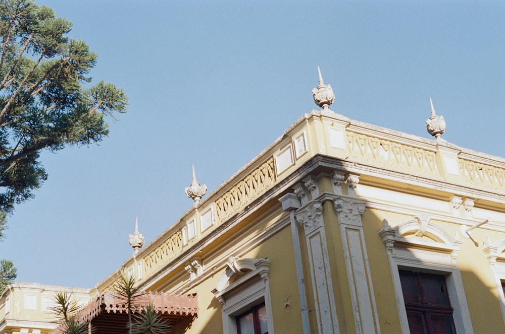 a yellow building with a tree in front of it