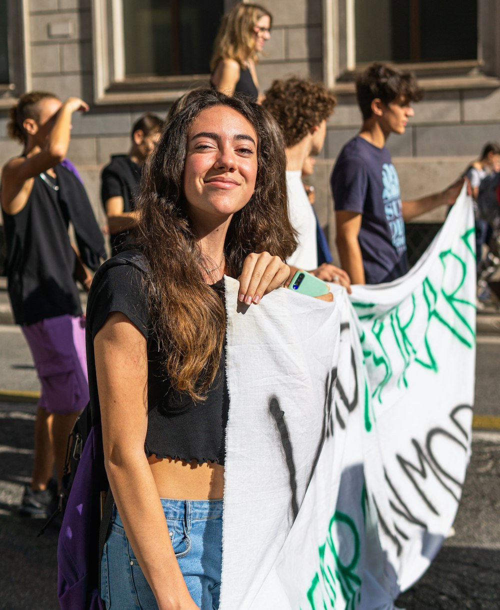 a woman holding a sign in front of a group of people