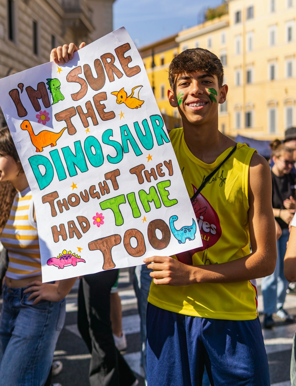 a boy holding a sign that says i'm sure the dinosaur thought they had