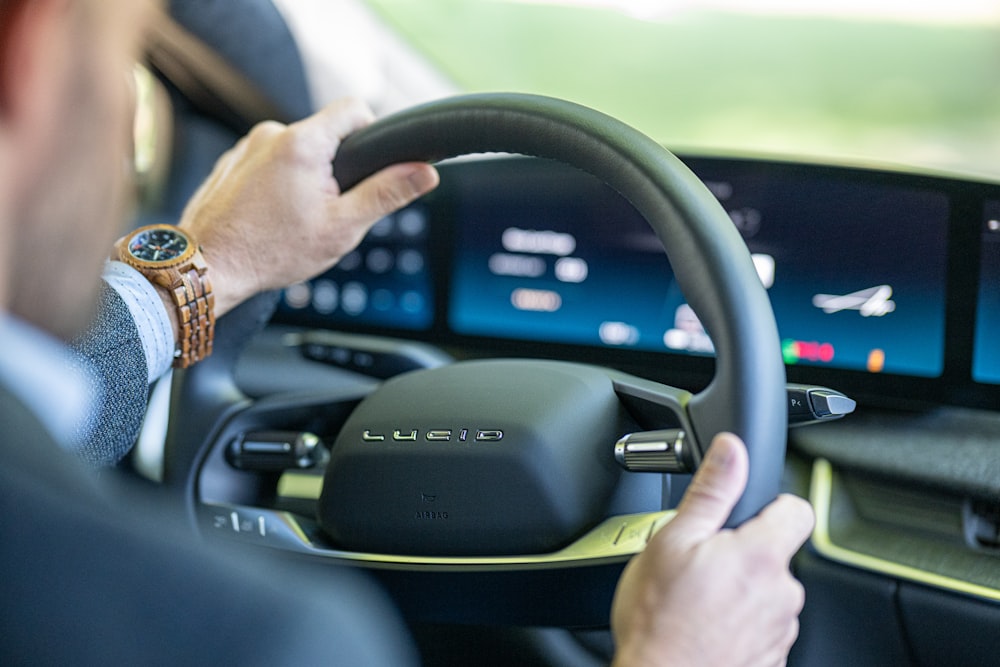 a man driving a car with a steering wheel