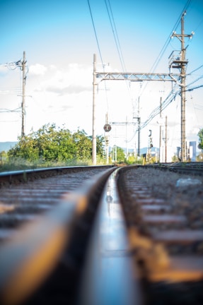 A close-up of railway tracks with a clear blue sky.