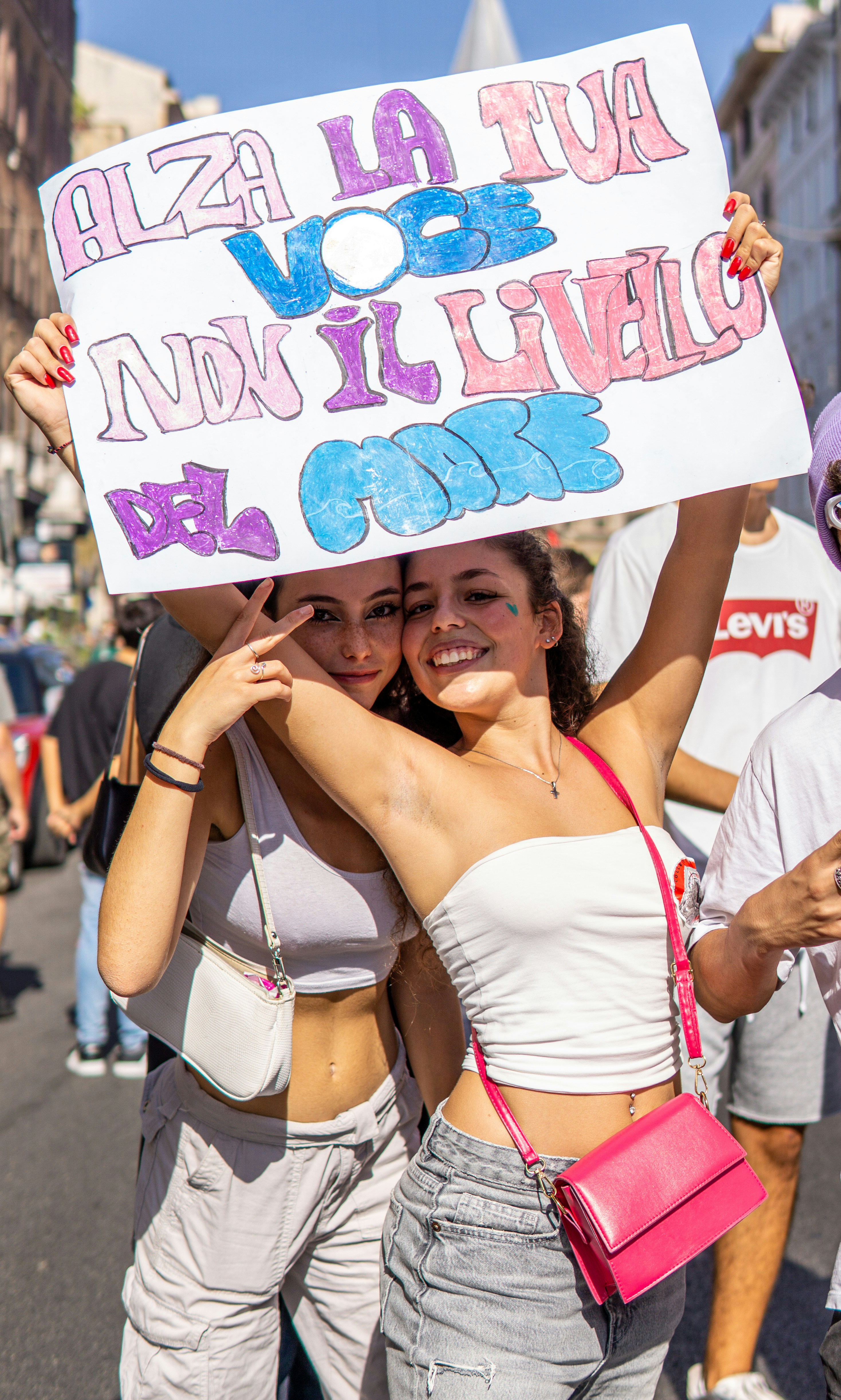 two women holding a sign in the middle of a street