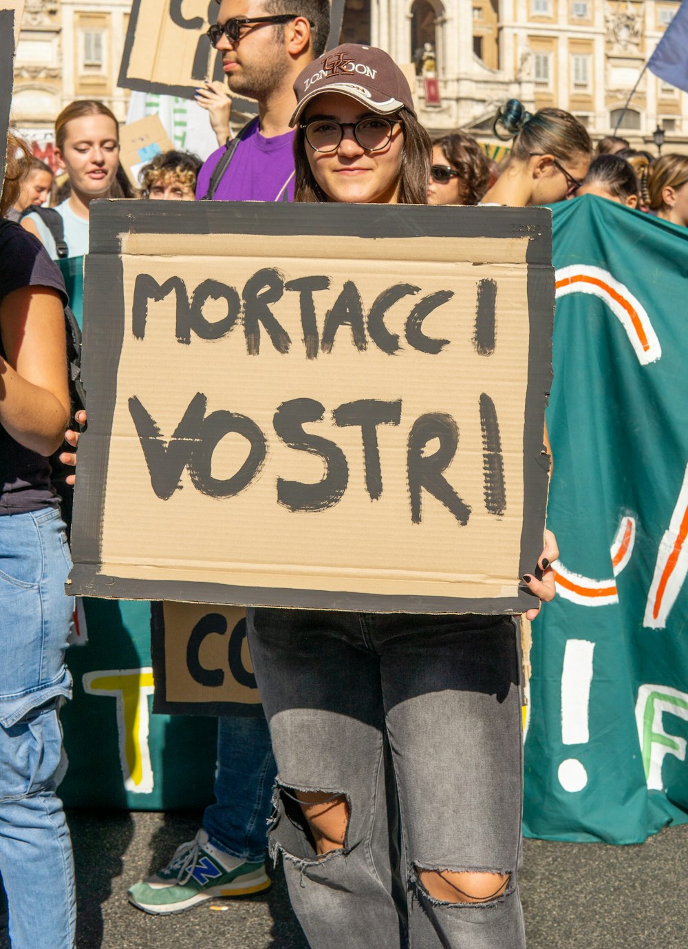 a woman holding a sign in front of a crowd