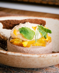 Plated dessert with a delicate drizzle of sauce and edible flowers.