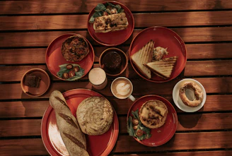 A rustic wooden table filled with handmade sandwiches and fresh breakfast ingredients from Mersin Viranşehir.