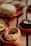 A variety of baked goods, including a round pastry with a golden crust and green filling, arranged on small, red ceramic dishes. In the background, the out-of-focus bread and a chocolate dessert add to the warm atmosphere.