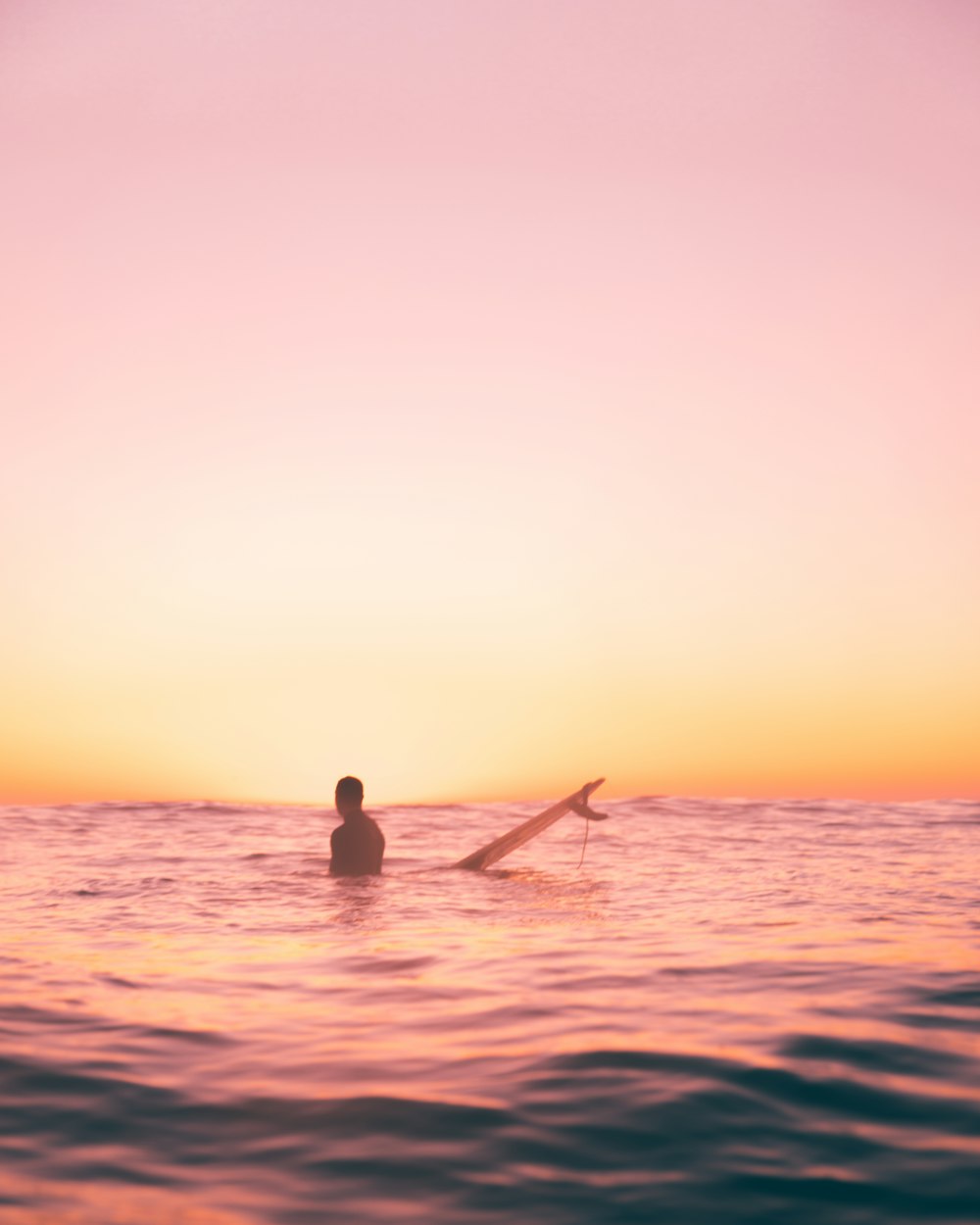 a person in the water with a surfboard