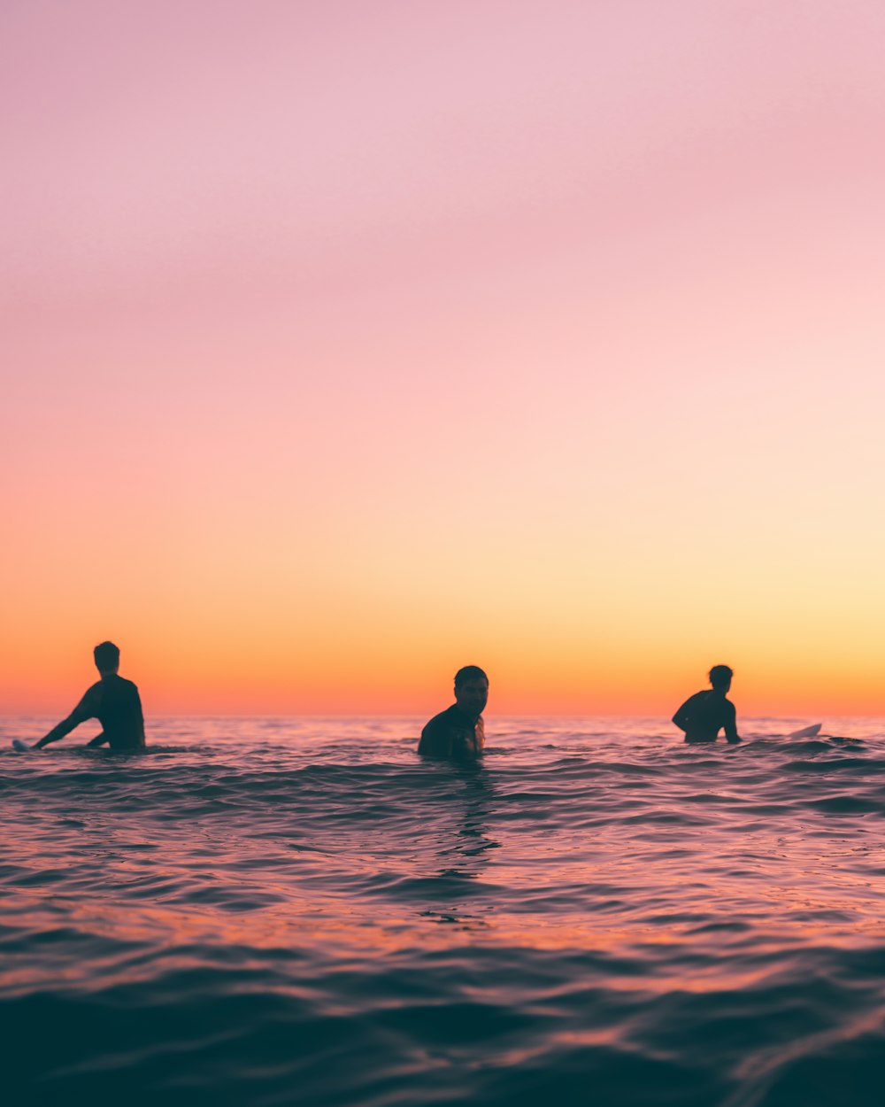 a group of people riding surfboards on top of a body of water