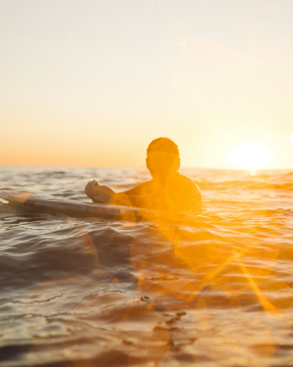 a man riding a surfboard on top of a body of water