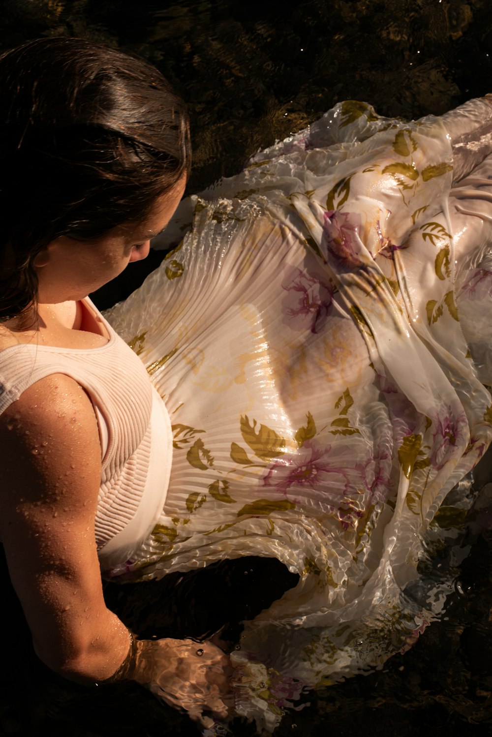 a woman in a white dress laying on the ground