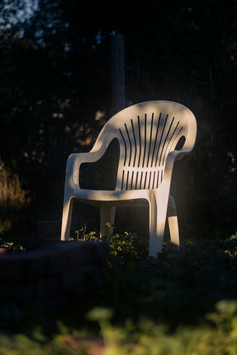 a white plastic chair sitting in the grass